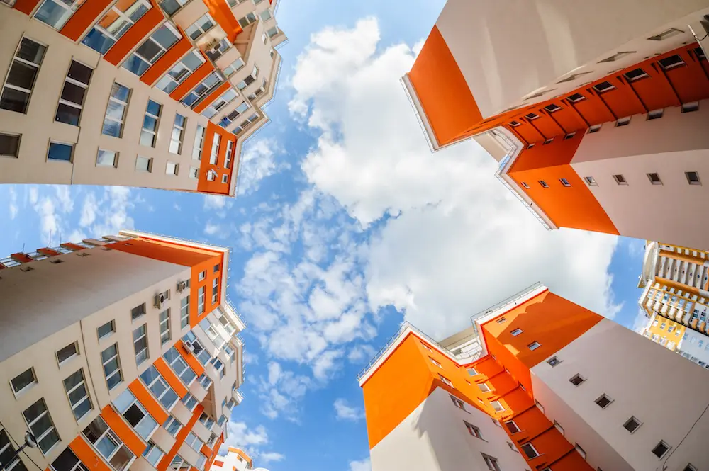 Apartment buildings photographed from below against a blue sky