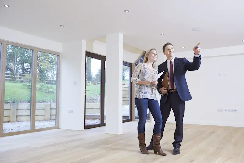 A leasing agent showing a prospective tenant an empty apartment