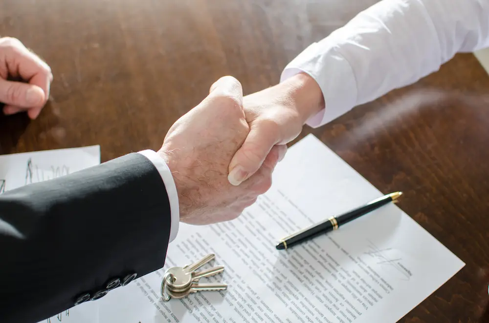 A handshake over a signed lease agreement and a set of keys
